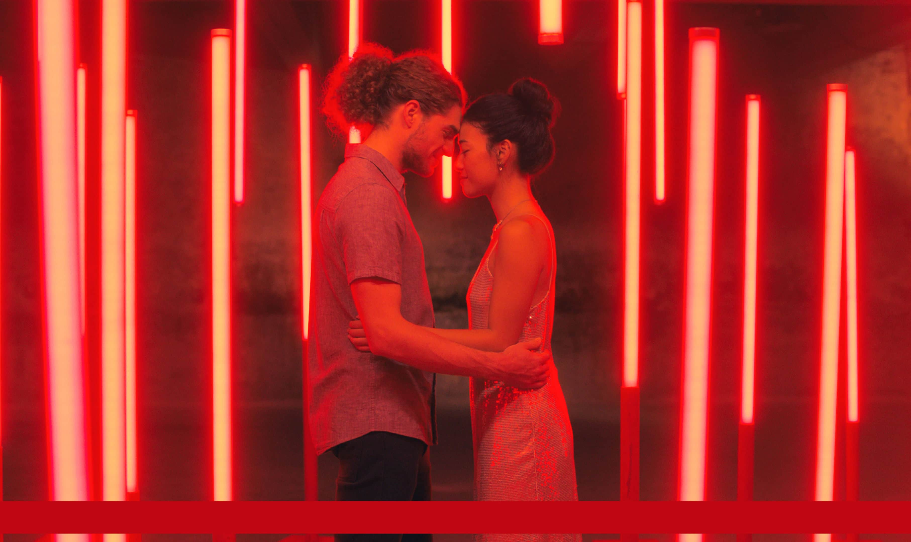 A couple holding each other with a red background