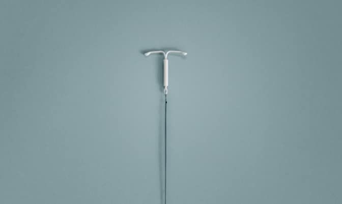 Mirena (levonorgestrel-releasing intrauterine system) 52mg IUD on a blue background