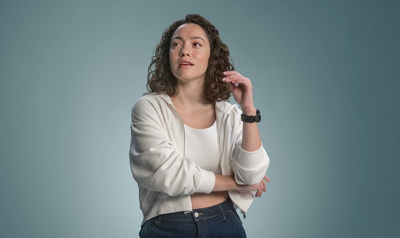 Image of a woman wearing a white hoodie gazing upward